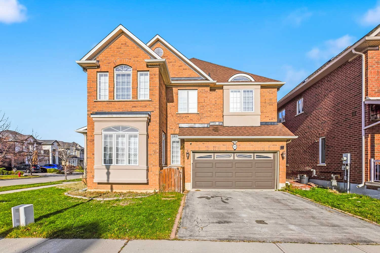 The same red-brick two-storey GTA home photographed in flat midday light, before digital twilight editing. RCG Canada real estate photography