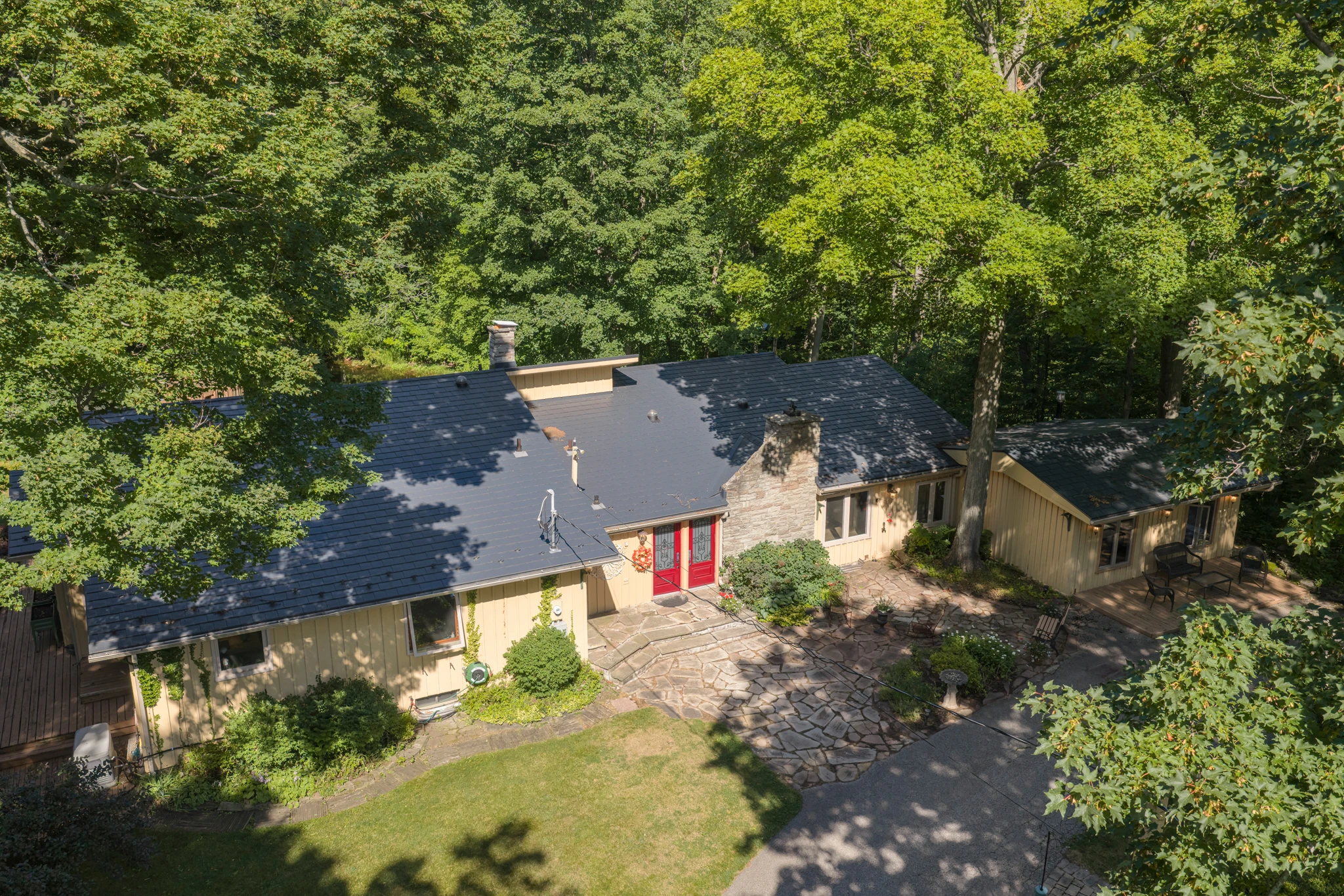 Aerial drone photograph of a wooded Heritage Road estate, the lot and tree canopy visible in a single frame