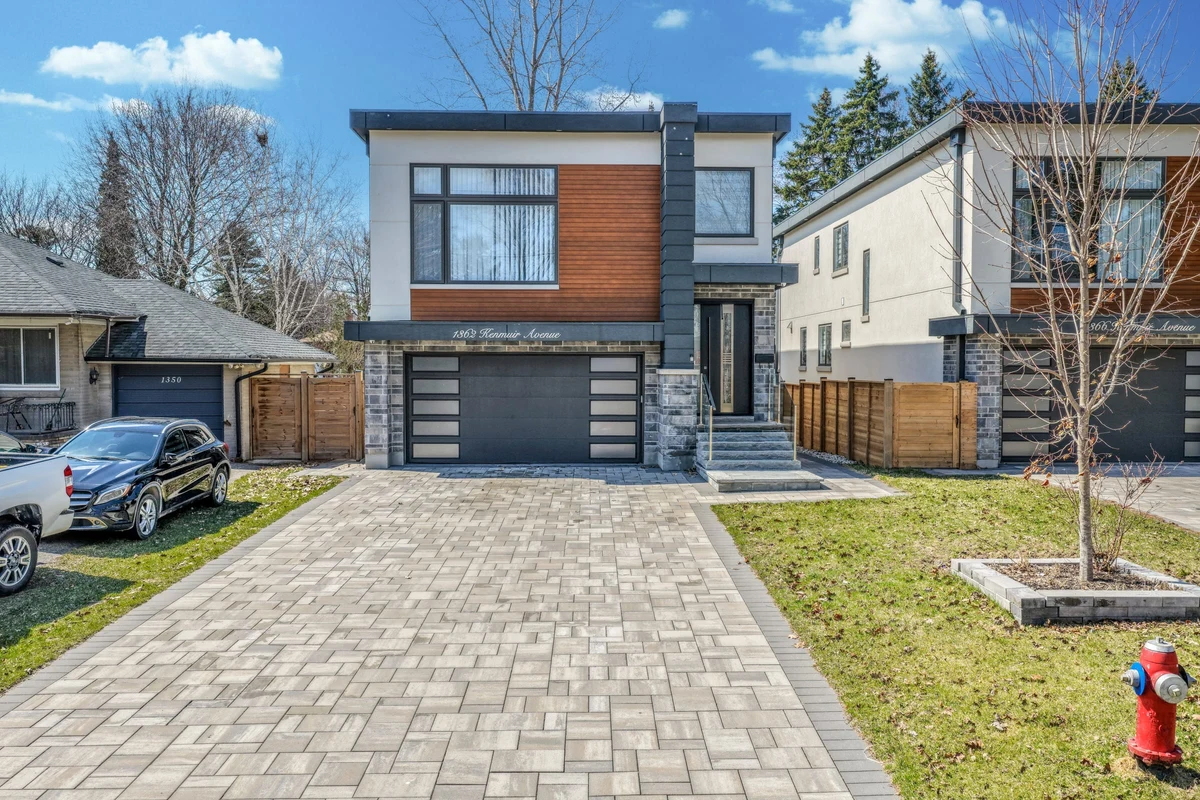 Straight-on aerial drone photograph of a Mississauga home's stone and wood-panel front façade with paver walkway. RCG Canada real estate photography