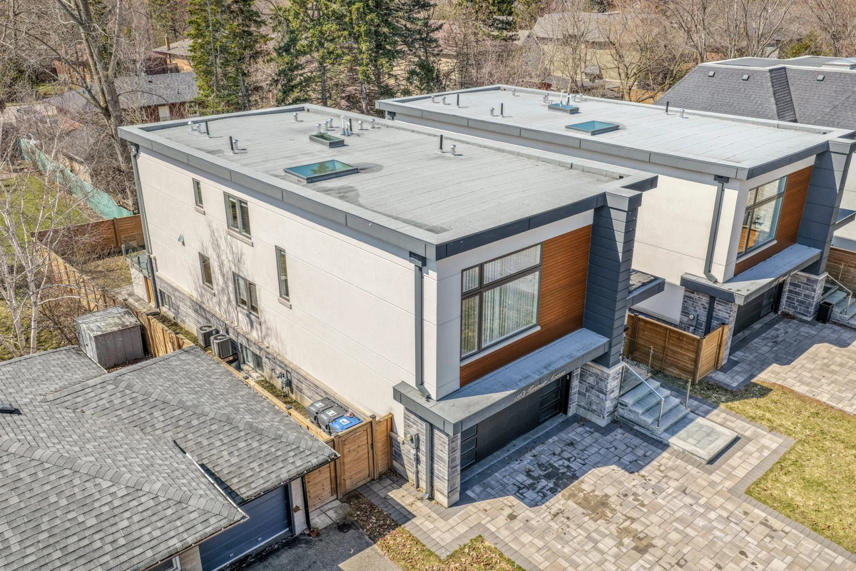 Drone aerial view of a Mississauga home's rooflines, glass-railed terrace and landscaped side yard. RCG Canada real estate photography