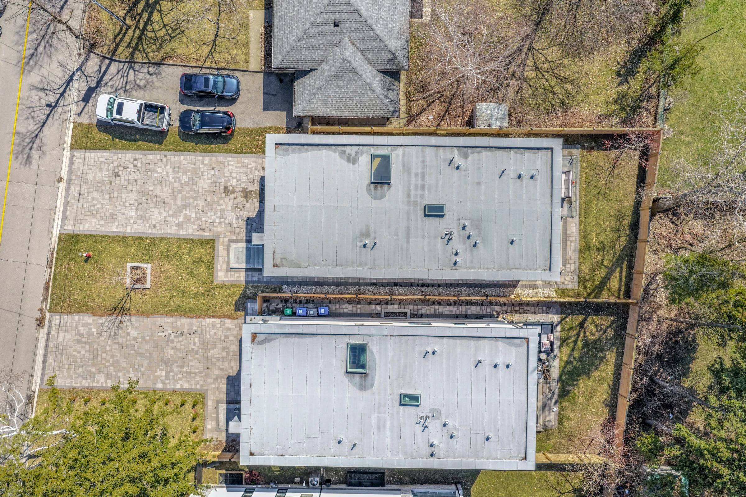 Top-down aerial drone photograph of twin modern rooflines and the paver driveway - RCG Canada