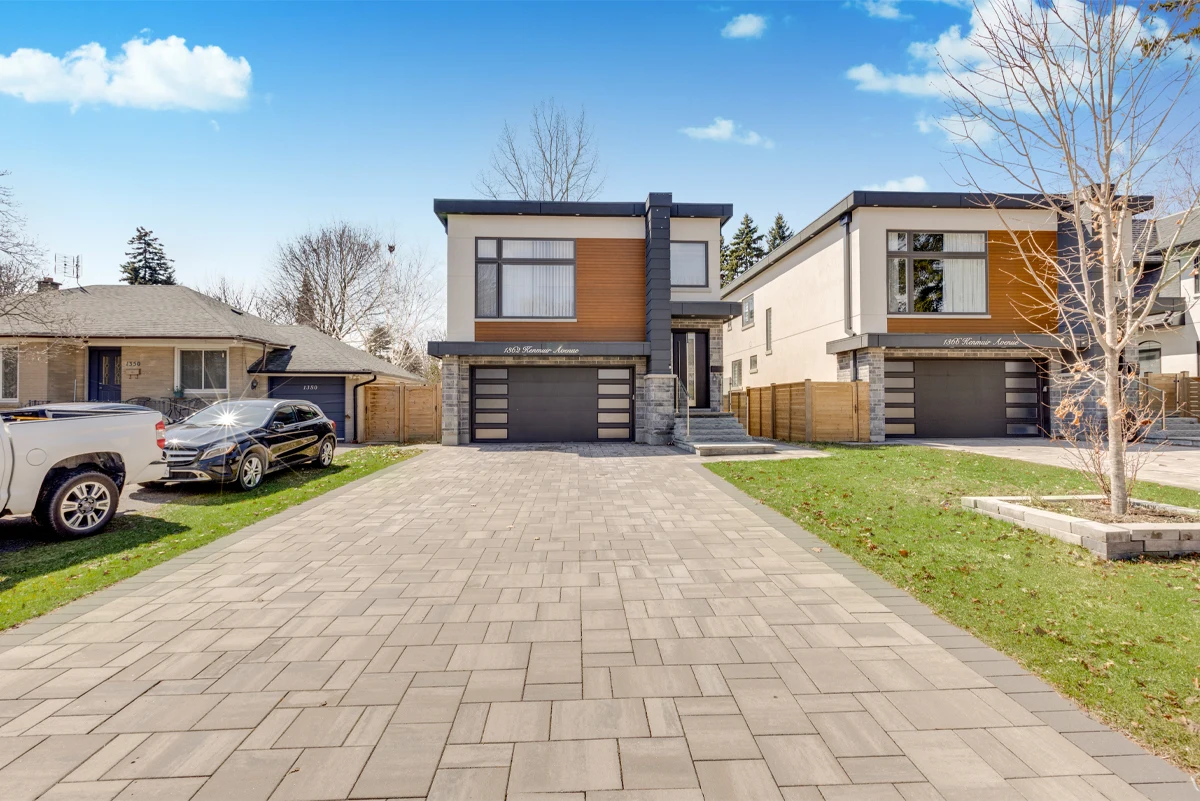 Straight-on exterior photograph of a Mississauga custom home showing both matching new-build façades in cedar panelling, stucco and stone. RCG Canada real estate photography