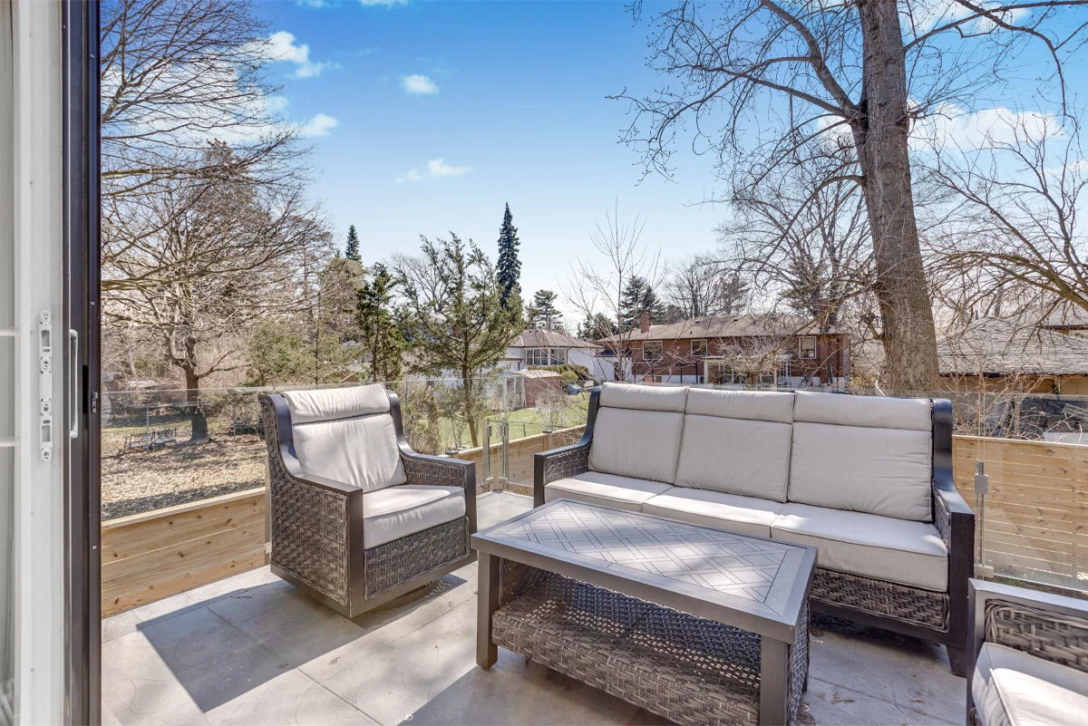 Wide view from a Mississauga home’s rear terrace across the backyard and neighbouring rooftops, with outdoor lounge seating in the foreground. RCG Canada real estate photography