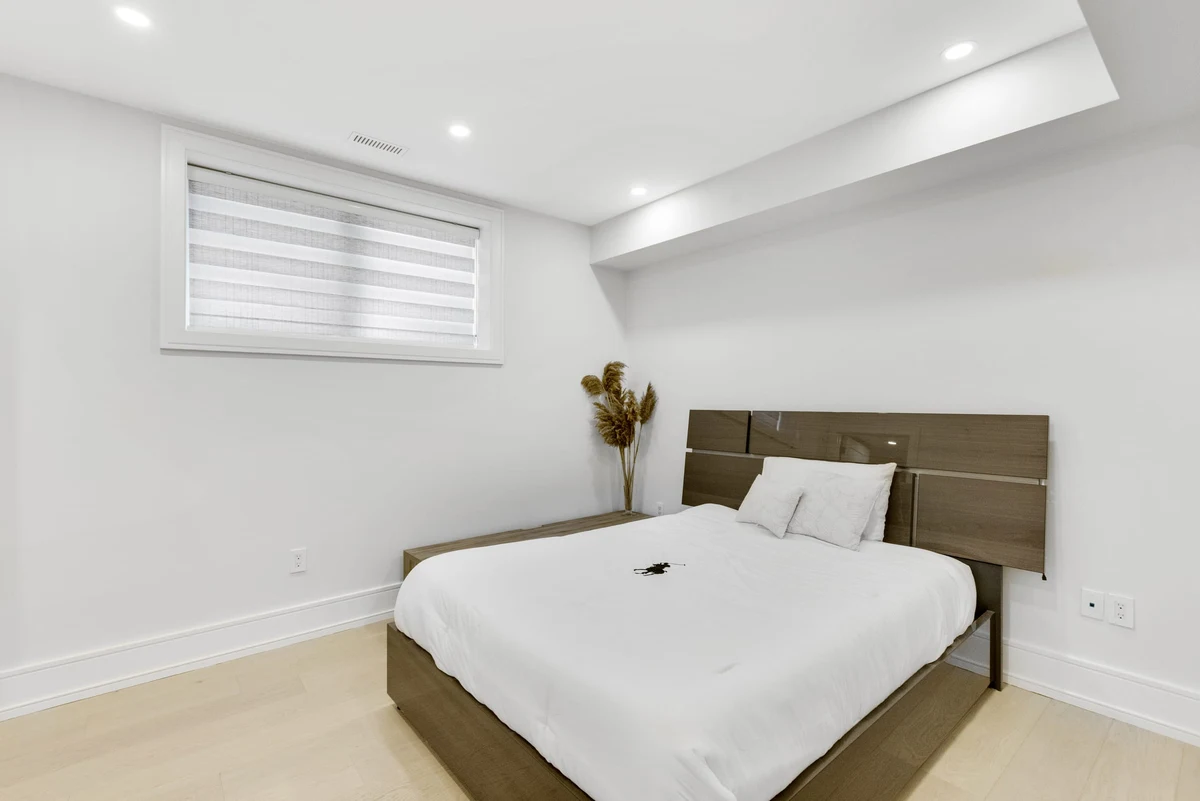 Serene secondary bedroom in soft blue-grey tones with designer bedding and dried pampas accents in a Mississauga home. RCG Canada interior photography
