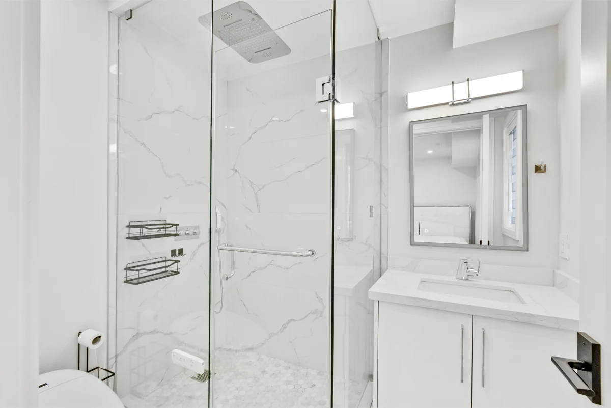 Ensuite bathroom with a marble-slab walk-in shower, rainhead, hex-tile floor and quartz vanity in a Mississauga home. RCG Canada interior photography