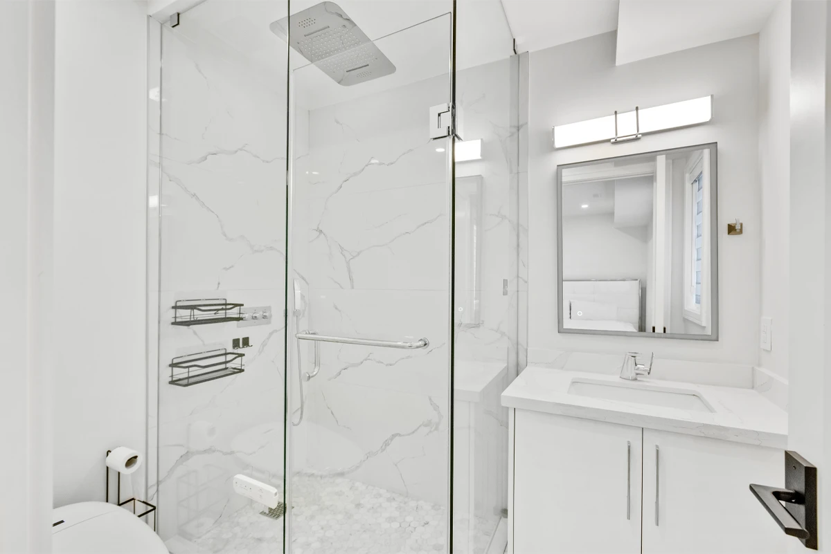 Ensuite bathroom with a marble-slab walk-in shower, rainhead, hex-tile floor and quartz vanity - RCG Canada