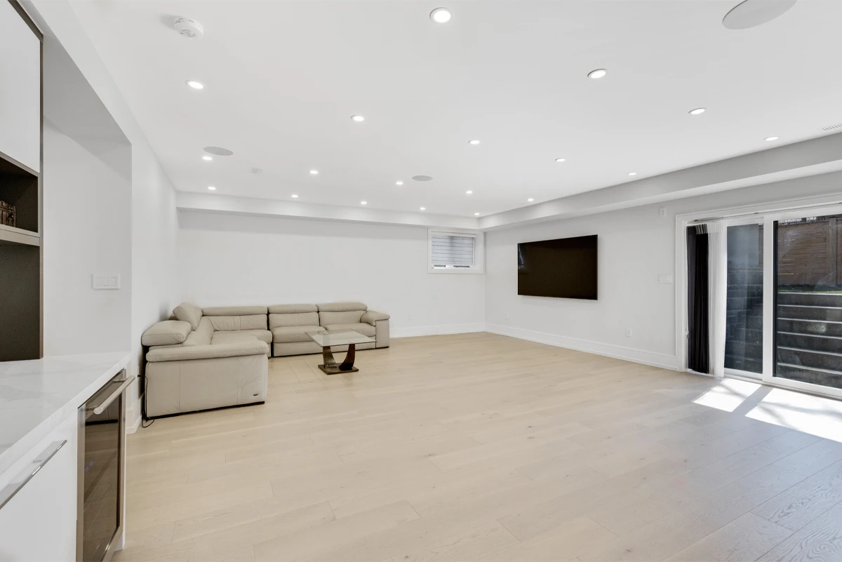 Lower-level recreation room with a wet bar, wine fridge and sliding walkout to the backyard - RCG Canada